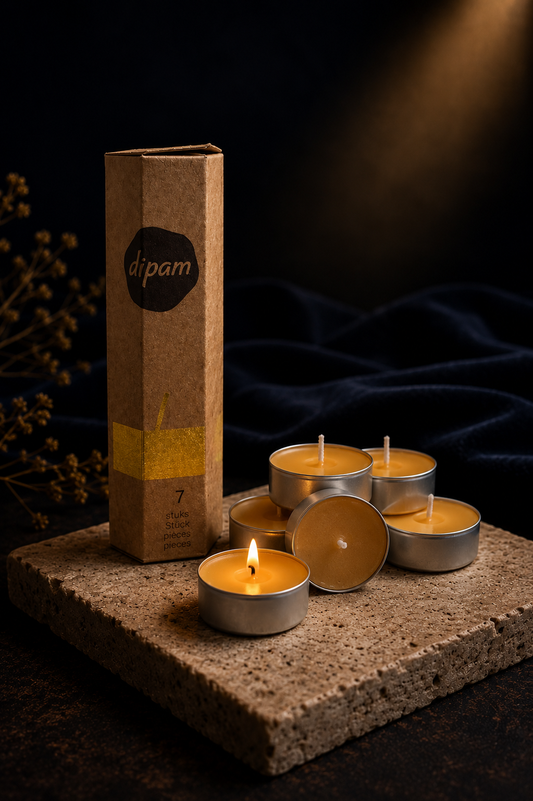 Natural beeswax tealight candles with cotton wicks on a travertine stone tray